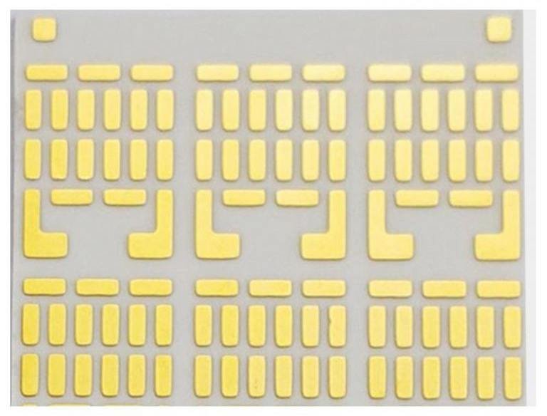 Ceramic circuit carrier with repeated rectangular gold-colored pads